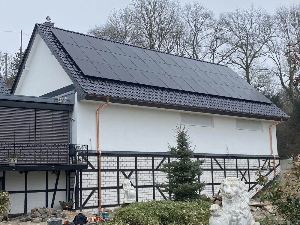 Zu sehen ist ein renoviertes Einfamilienhaus mit neuer Fassade, neuem Dach und neuer Photovoltaikanlage von Firstetage Leverkusen.