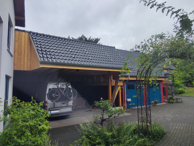 Das Bild zeigt einen großen, neuen Carport mit neu eingedecktem Dach von Firstetage Leverkusen.