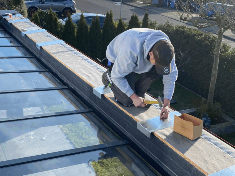 Zu sehen ist ein Mitarbeiter von Fistetage Leverkusen, er bearbeitet ein Flachdach und bringt Flachdachabdichtungen an.